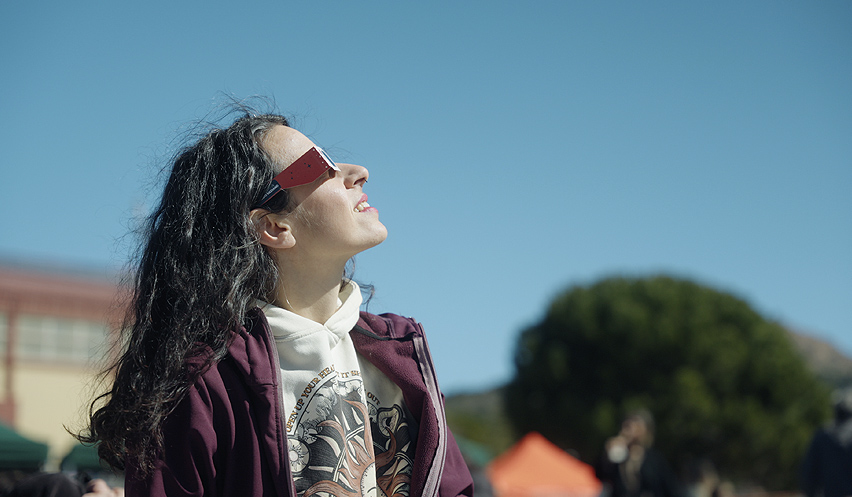 Fotografía de una mujer joven mirando al cielo con gafas protectoras.