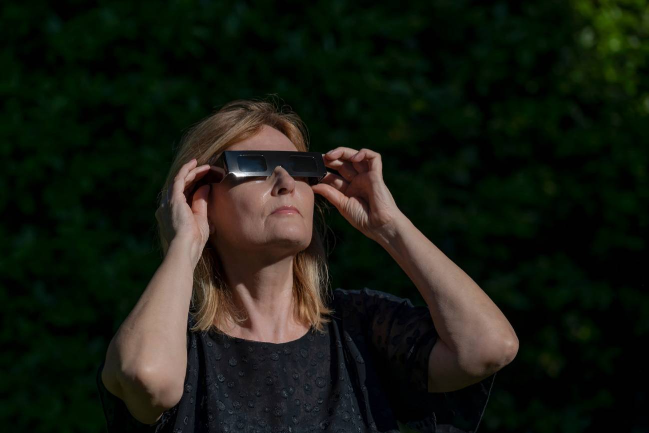 Mujer observando el sol con unas gafas especiales para eclipses